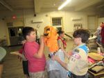 Scouts putting a rubber pumpkin head on a scarecrow