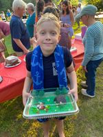 a boy posing next to a cake