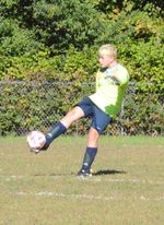 a child kicking a soccer ball