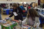 two people looking at boxes of books