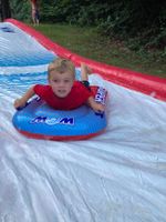 A child riding down a water slide on a tube