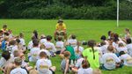 A man teaching the Bible to children gathered outdoors