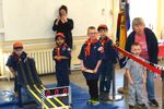 several scouts standing around a pinewood derby track