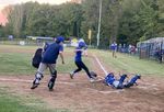 a baseball player approaches home base as the catcher tries to tag it