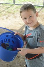 a boy with a bucket of plastic eggs