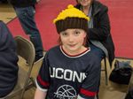 a child wearing a hat shaped like a chocolate cupcake with yellow frosting