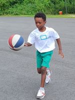 a boy running with a basketball