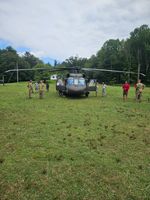 a helecopter with by people in military uniforms