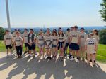 a group of students pose in front of a long-distance view of a city