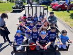 children in blue baseball uniforms in a trailer