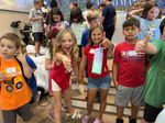 a few children giving thumbs-up and smiling