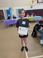 a child holding an award