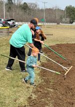 a group of people raking dirt