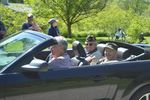 veterans riding in a dark green sports car