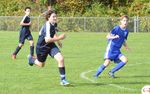 three children playing soccer