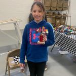 a child holding a lego car and a prize