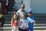children posing with prizes with an adult