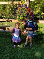 two children posing in front of a boquet