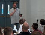 Adam Minor speaking into a microphone