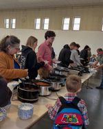 people getting chili from crock pots