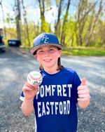A smiling boy holding a baseball