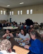 people eating at tables in a gymnasium