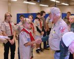 A Scoutmaster shaking hands with a scout