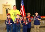 a few cub scouts posing with an adult