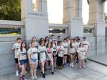 a group of students posing on fron of the word "Connecticut" carved into a granite pillar