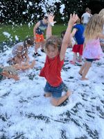 children playing in soap-foam that looks like snow