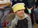 a child wearing a hat shaped like a yellow cupcake