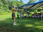 A woman singing in front of the tent