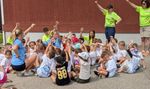 a group of children and adults holding up their hands