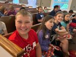 children smiling in a church pew