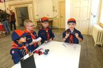 a few cub scouts, looking at another holding his pinewood derby car