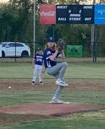 a child wearing a baseball uniform pitches a ball